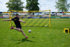 Voetballer schiet op het Quickfire groot voetbaldoel - 732x244cm tijdens een training, ideaal voor precisie- en schietoefeningen.