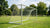 Aluminium voetbaldoel op een veld, klaar voor gebruik met een heldere blauwe lucht op de achtergrond.