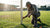 Een voetballer inspecteert een vast doel op veiligheid met een gereedschapskoffer ernaast.