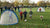 Mini voetbaldoelen staan op een grasveld, omringd door kinderen die met een bal spelen.