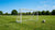 Een opvouwbaar mini doel naast een vast frame op een grasveld tijdens een zonnige dag.