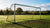 Roestige stalen voetbalgoal met beschadigde netten op een specifiek trainingsveld.