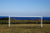 Versleten doelnet op voetbaldoel met zeezicht op achtergrond.