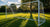 Versleten voetbaldoel met roest en beschadigde netten op een grasveld onder een bewolkte lucht.