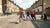 Een groep jongeren speelt straatvoetbal op een betonnen plein met graffiti op de muren.